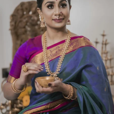 Woman in a green silk saree with a purple border