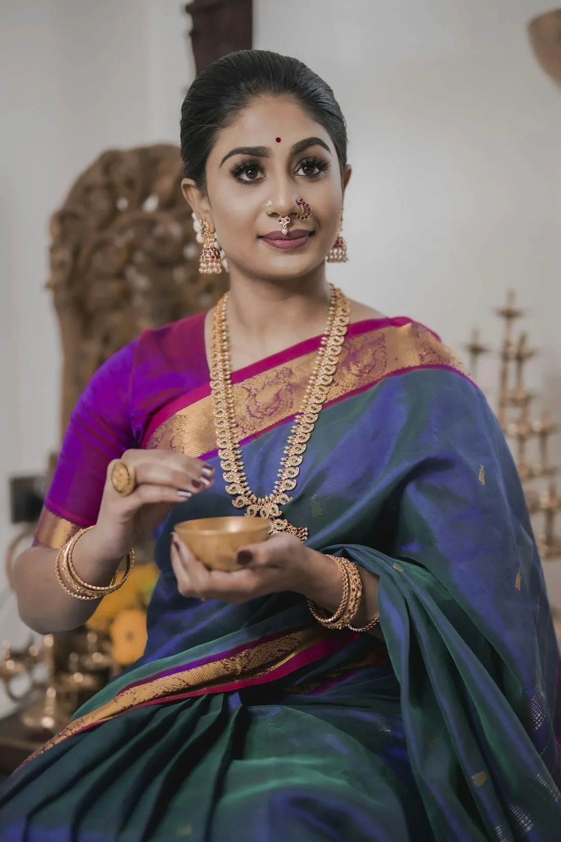 Woman in a green silk saree with a purple border