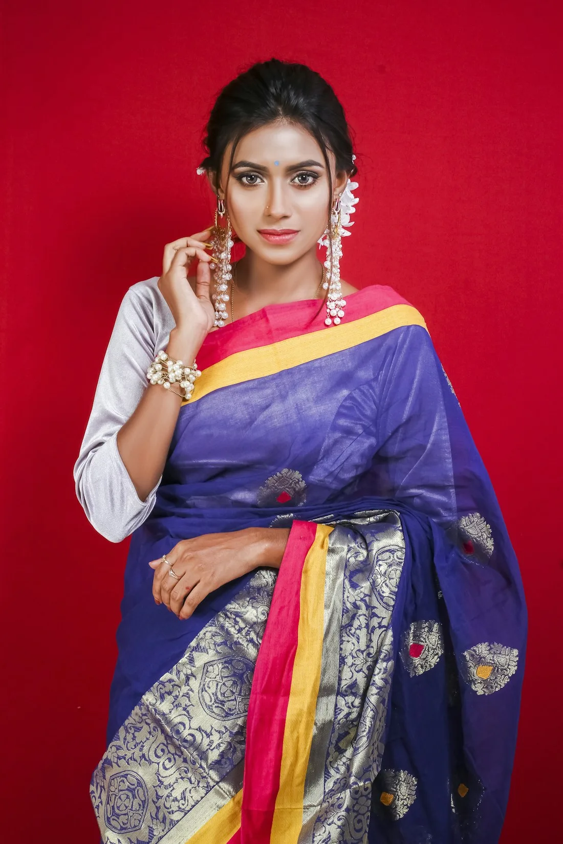 Woman in a blue silk saree with a yellow border
