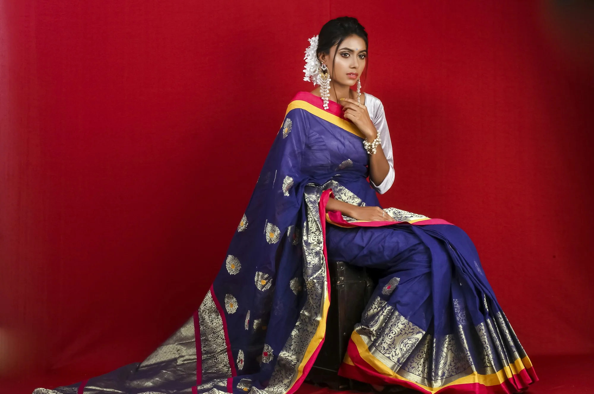 Woman in a royal blue silk saree with a gold border