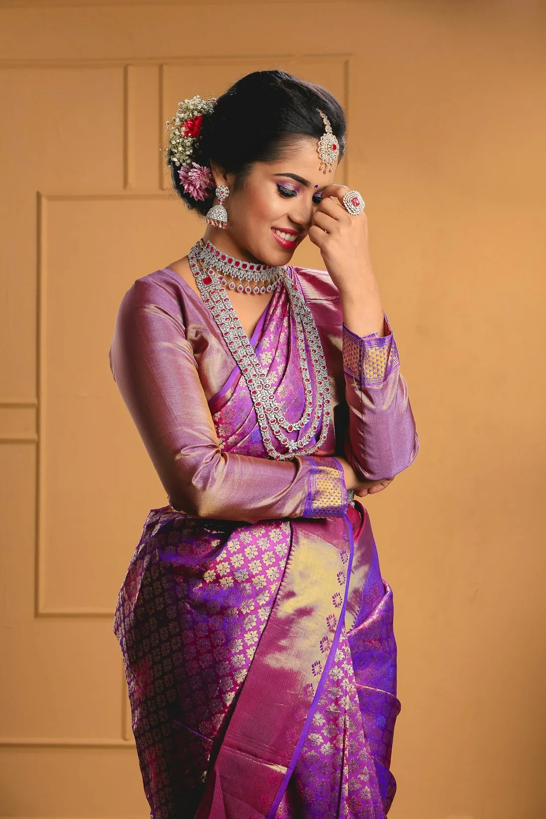 Woman in a purple and gold silk saree with jasmine