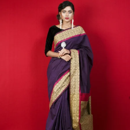 Woman in a purple silk saree with a gold border