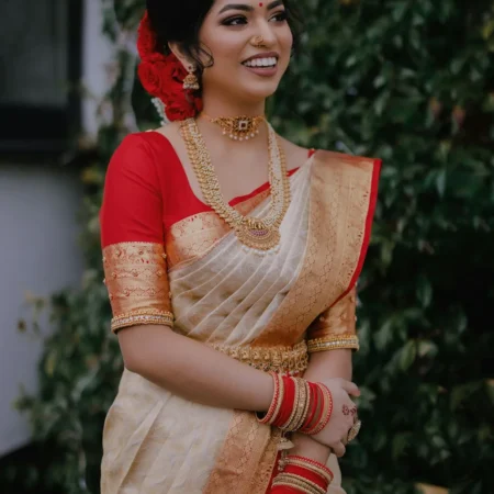 Woman in an ivory saree with a red border