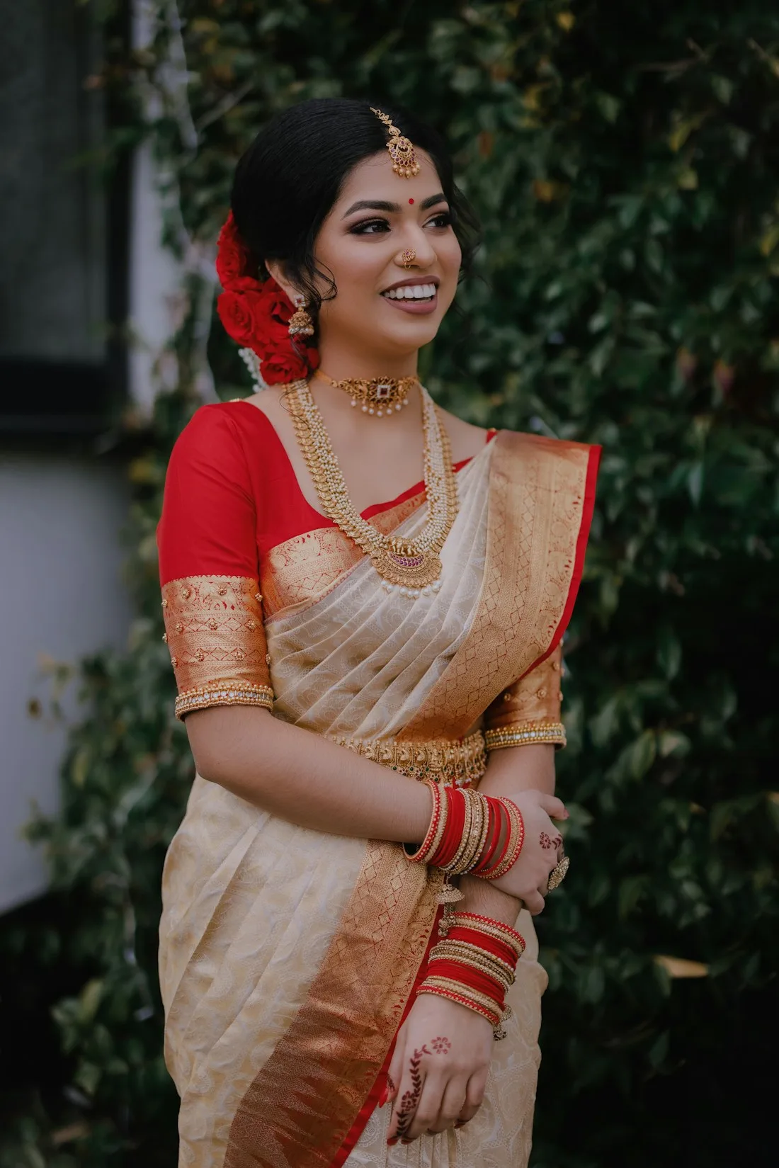 Woman in an ivory saree with a red border